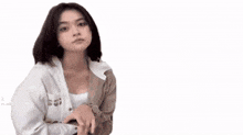 a woman in a white shirt is sitting in front of a sign that says salam silatu