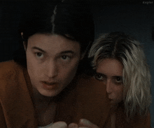 a man and a woman are looking at each other and the man says what the fuck