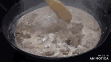 a pot of soup is being stirred with a wooden spoon and the words made in animatica are on the bottom