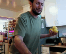 a man in a green shirt is crying while holding lemons