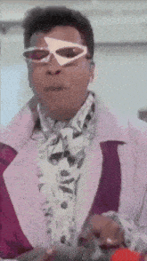 a man wearing sunglasses and a pink jacket