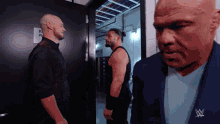 a man in a blue suit has a wwe logo on his jacket