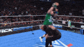 a man in a green shirt is being lifted in the air by another man in a wrestling ring that says mack down