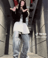 a woman is dancing in a hallway with a tiktok watermark on the bottom
