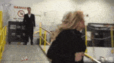 a woman is walking down stairs in front of a sign that says danger on it