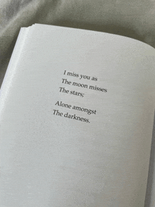 a book open to a page that says " i miss you as the moon misses the stars alone amongst the darkness "