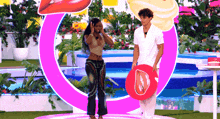 a man and a woman are standing next to each other on a stage in front of a pool .