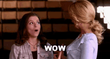 two women are standing next to each other and one of them is making a surprised face .