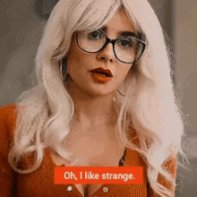 a woman with blonde hair and glasses is wearing a wig and a sweater .