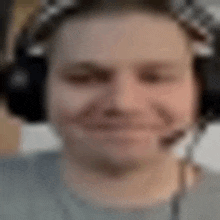 a man is wearing headphones and a microphone and smiling .