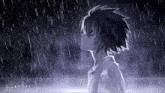 a boy is standing in the rain with his eyes closed and looking up at the sky .