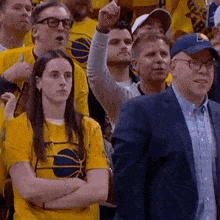 a group of people are watching a basketball game .