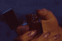 a woman with long pink nails is holding a lighter in her hand