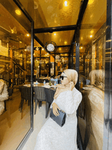 a woman in a white dress is sitting in front of a restaurant