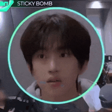 a close up of a person 's face in a circle with the word sticky bomb on it .