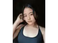 a woman wearing a black tank top and a silver necklace with the letter k on it