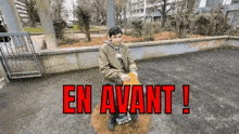 a boy sits on a seesaw with the words en avant written in red letters