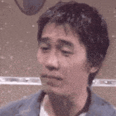 a close up of a man 's face with his eyes closed and a microphone in the background .