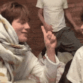 a woman with a scarf around her head is giving a thumbs up