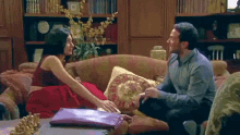 a man and a woman are sitting on a couch in a living room .