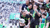 a group of women holding a trophy with the number 6 on their shirt