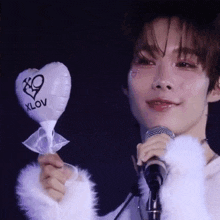 a man is holding a heart shaped balloon that says xlov on it
