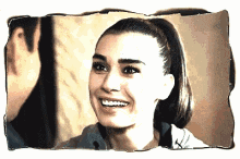 a woman in a ponytail is smiling in a frame