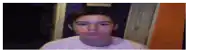a young man is making a funny face in front of a camera .