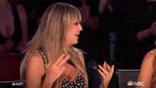 a woman sitting in front of a microphone with the word nbc on the bottom right