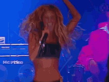 a woman singing into a microphone in front of a hartke amp