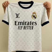 a person holds up a white emirates fly better shirt