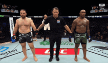 a referee stands between two fighters in a ufc match