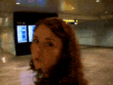 a woman stands in front of a sign that says ' departures '