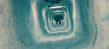 a person is walking through a tunnel that looks like a tunnel of ice