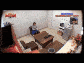 a woman sits on a chair in a living room with a sign above her that says ' sd '