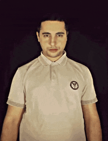 a man wearing a white polo shirt with a greek key pattern on the sleeves