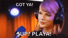 taylor swift is wearing headphones and talking into a microphone with the words `` got ya ! sup ? playa ! ''