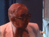 a man wearing glasses and a white suit is featured on the lady channel