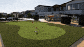 a lawn with a putting green and a dining area in the background