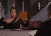 a woman is sitting at a table with a man in a suit .
