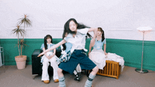 a group of girls are sitting on a couch and one is dancing