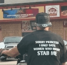 a man wearing a shirt that says " sorry princess i only date women who might stab me "