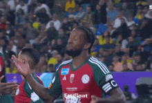 a soccer player wearing a red and green jersey with hongdi on it