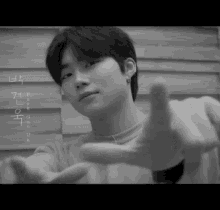 a black and white photo of a young man making a gesture with his hand
