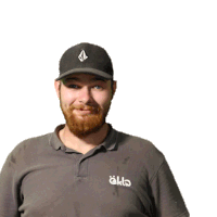 a man with a beard wearing a black hat and a grey shirt that says okl