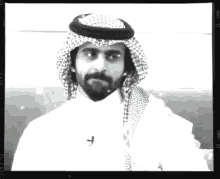 a black and white photo of a man with a beard wearing a turban