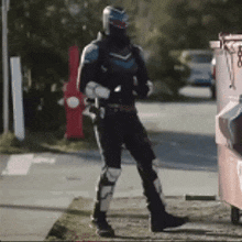 a man in a superhero costume is standing on the sidewalk