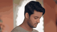 a young man with a beard is looking down