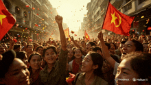 a crowd of people holding up red flags with a yellow star on it