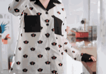 a person wearing a white shirt with black and red flowers on it